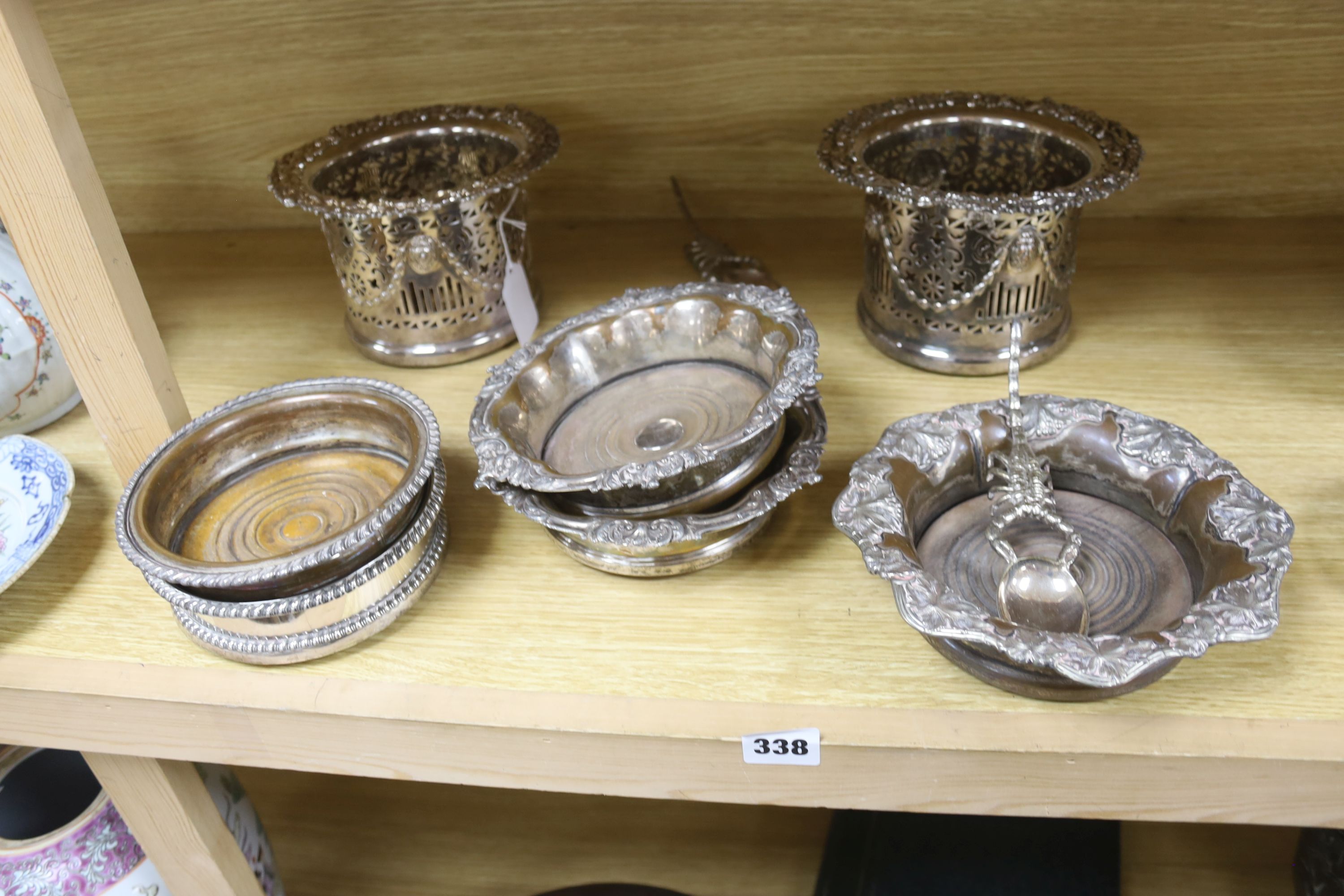 A pair of late Victorian pierced silver plated magnum coasters, height 12cm, two other pairs of plated wine coasters, one other and two spoons.